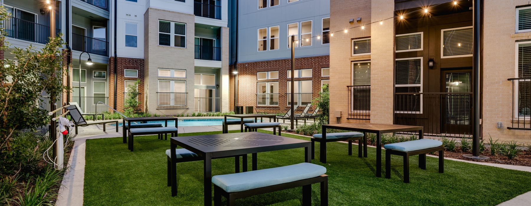 Turf courtyard area with picnic table and string lights